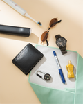 Collection of items including a black wallet, sunglasses, watch, pen, and bottle on a beige surface. Hold Up Magic Self Adhesive Wrap Organiser Mint Mojito
