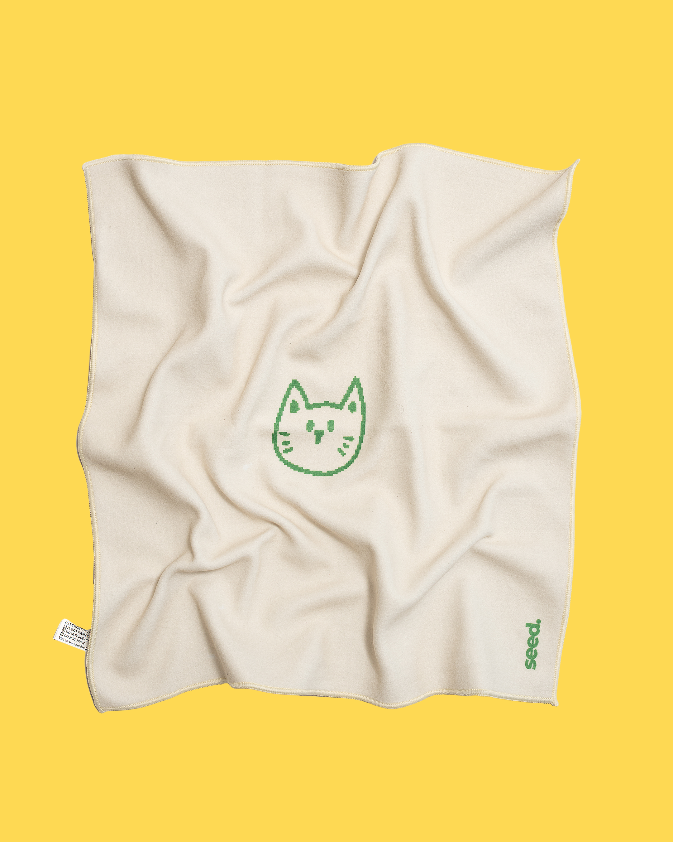 Beige towel with a green cat logo on a yellow background Hold Up Magic Self Adhesive Wrap  Organiser Cat In The Bag