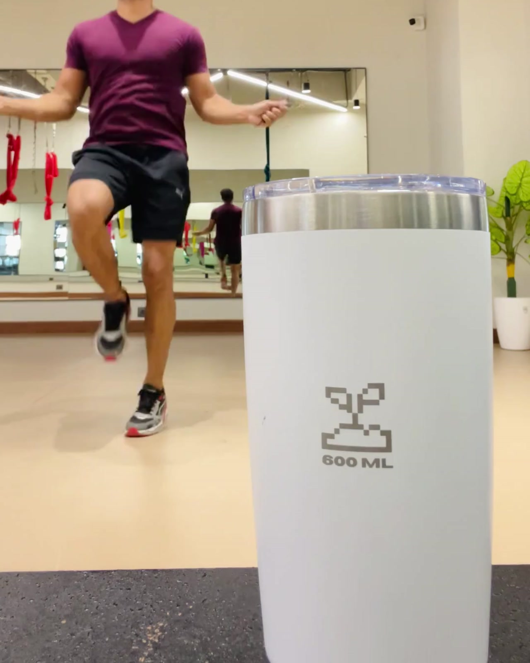 Person skipping rope in a gym with a white tumbler stainless steel tumbler with pre-workout in it 600mL moonlight insulated stainless steel travel coffee mug 600mL 