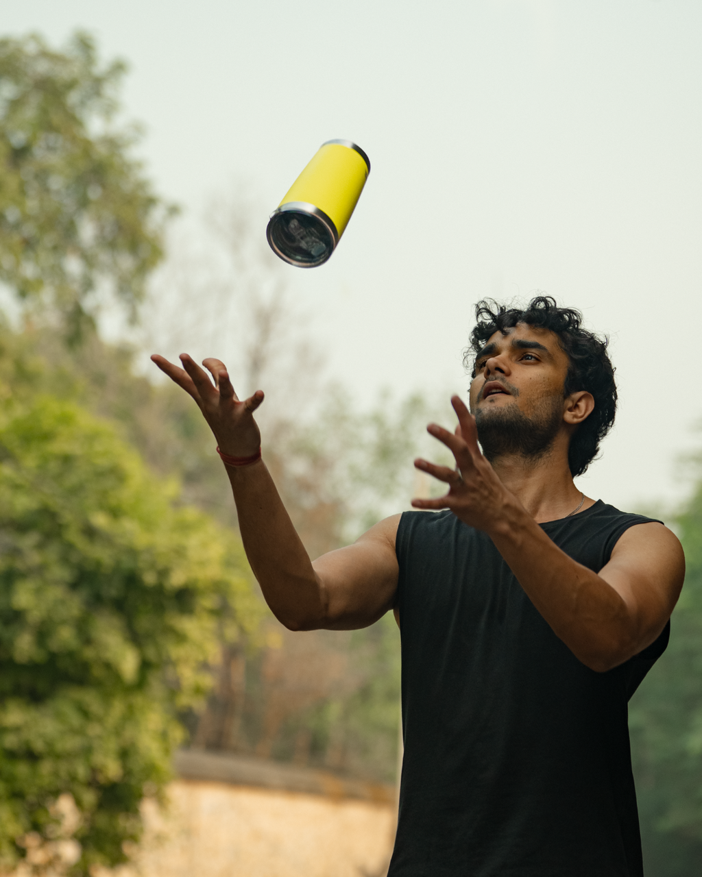 Man out on a run juggling a yellow stainless steel tumbler 600mL lemonade  insulated stainless steel travel coffee mug 600mL 