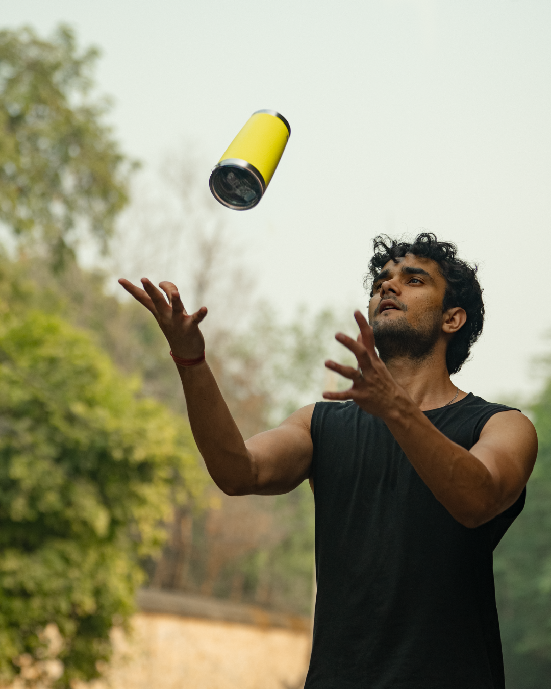 Man out on a run juggling a yellow stainless steel tumbler 600mL lemonade  insulated stainless steel travel coffee mug 600mL 